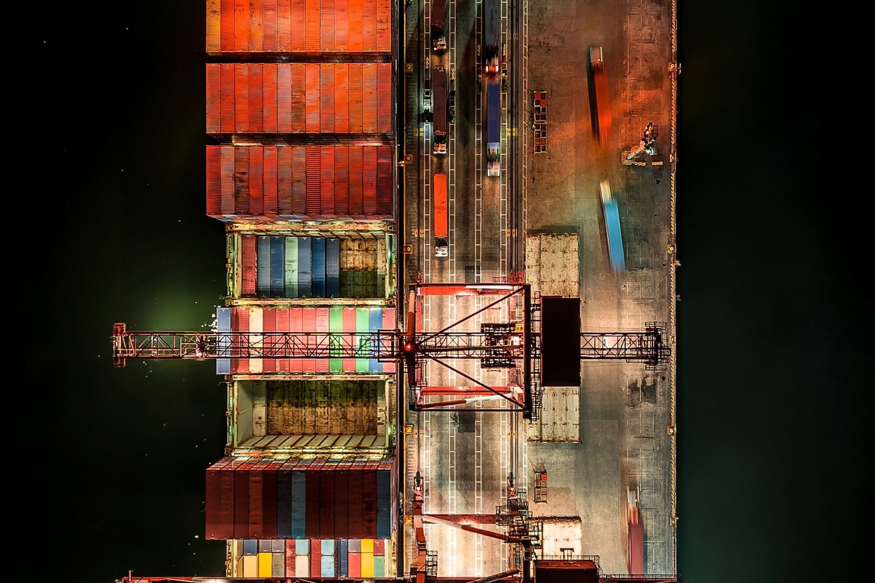 An illuminated container terminal and cargo vessel representing strategic opportunity.